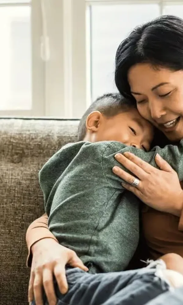 پسر بچه آسیایی در بغل مادر روی کاناپه